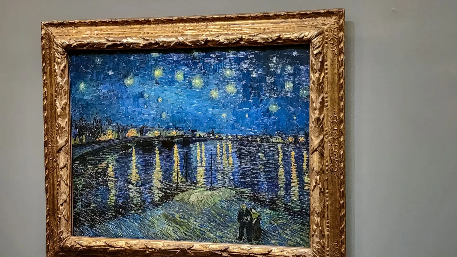 Van Gogh’s Starry Night Over the Rhône in a carved gilt frame at the Musée d’Orsay, gaslight reflected in long columns on dark blue water