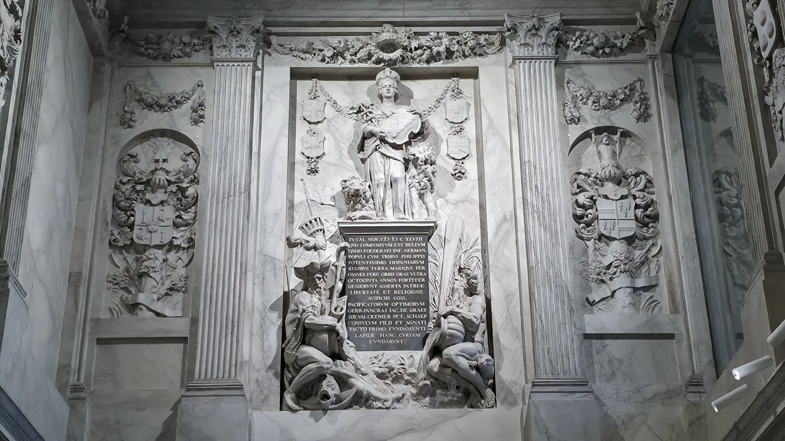 Marble foundation monument in the Vierschaar, Royal Palace Amsterdam, with the Maid of Amsterdam above a black inscription tablet