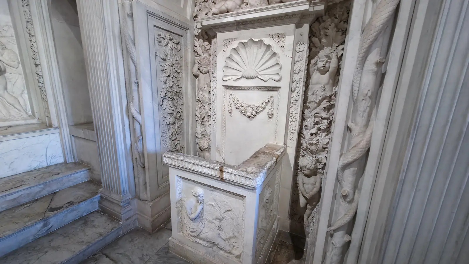 The city secretary’s marble seat in the Vierschaar, Royal Palace Amsterdam, with scallop shell, garland and a mourning figure