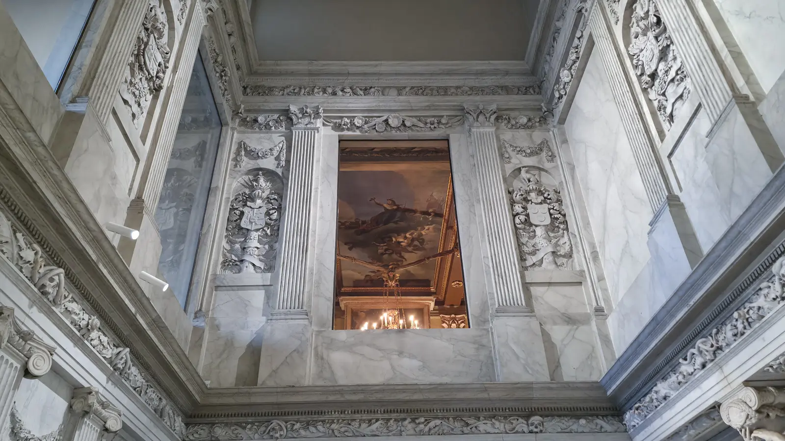 Opening high in the marble wall of the Vierschaar, Royal Palace Amsterdam, looking through to a lit painted interior above