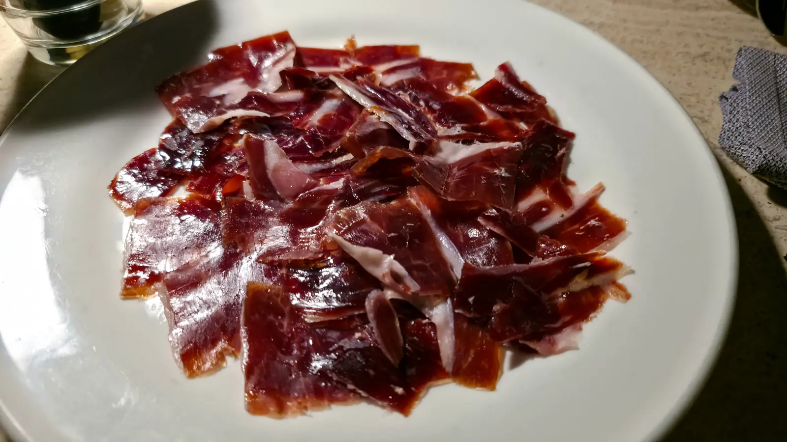 A plate of thinly sliced jamon de bellota 100% iberico at the W Lounge, W Amsterdam, served on white china