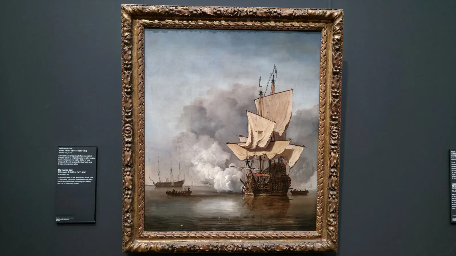 Willem van de Velde II’s painting of a Dutch warship firing a cannon shot in a calm sea, hanging on a grey wall at the Rijksmuseum