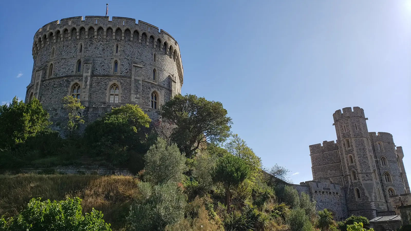 The Round Tower of Windsor Castle rising above its garden-covered mound, with a gatehouse tower to the right, on a day trip from London