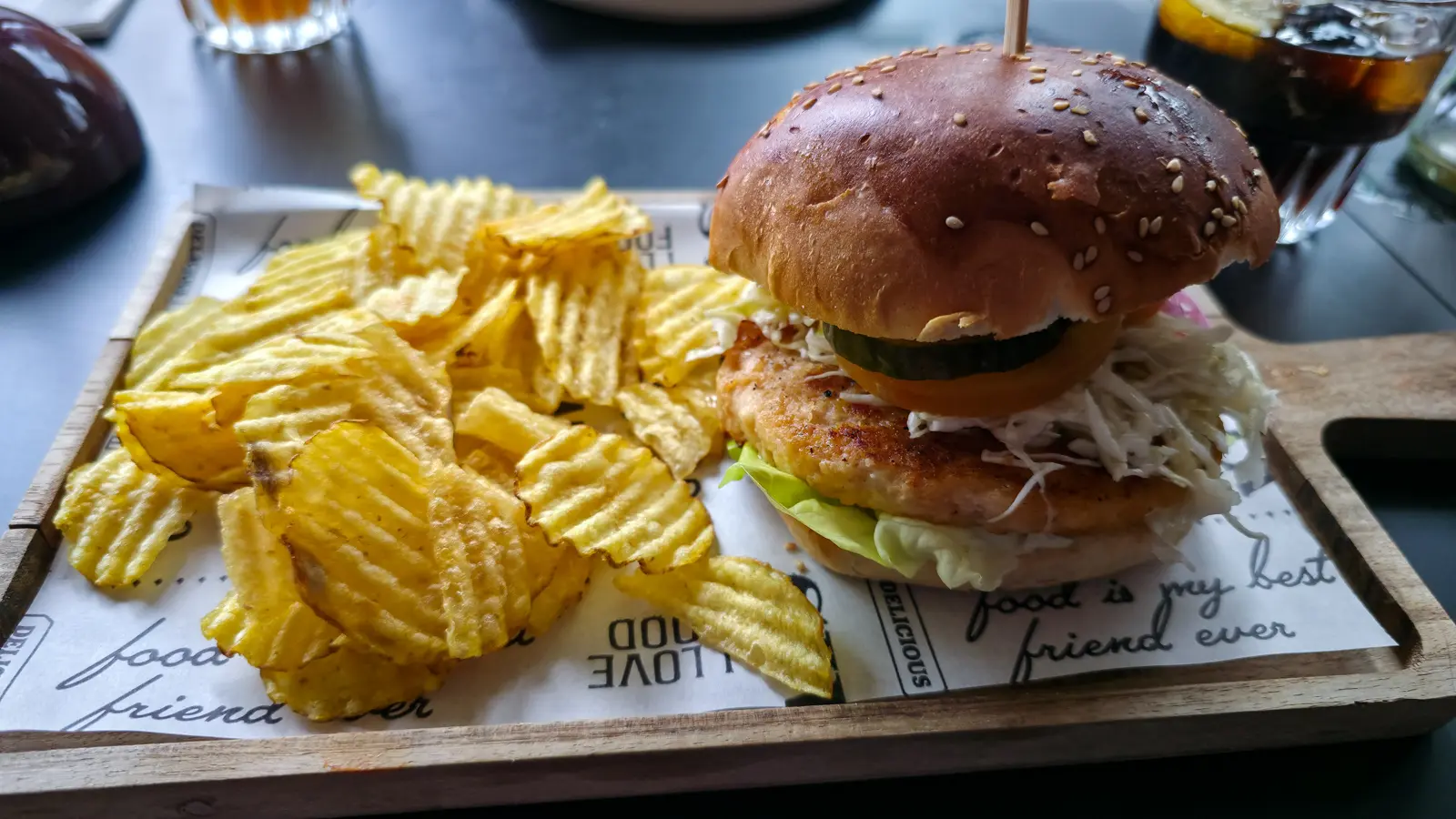 Lobster burger with crinkle-cut crisps on a wooden board at Bistro Vincent, Van Gogh Museum, Amsterdam, coleslaw spilling from the bun