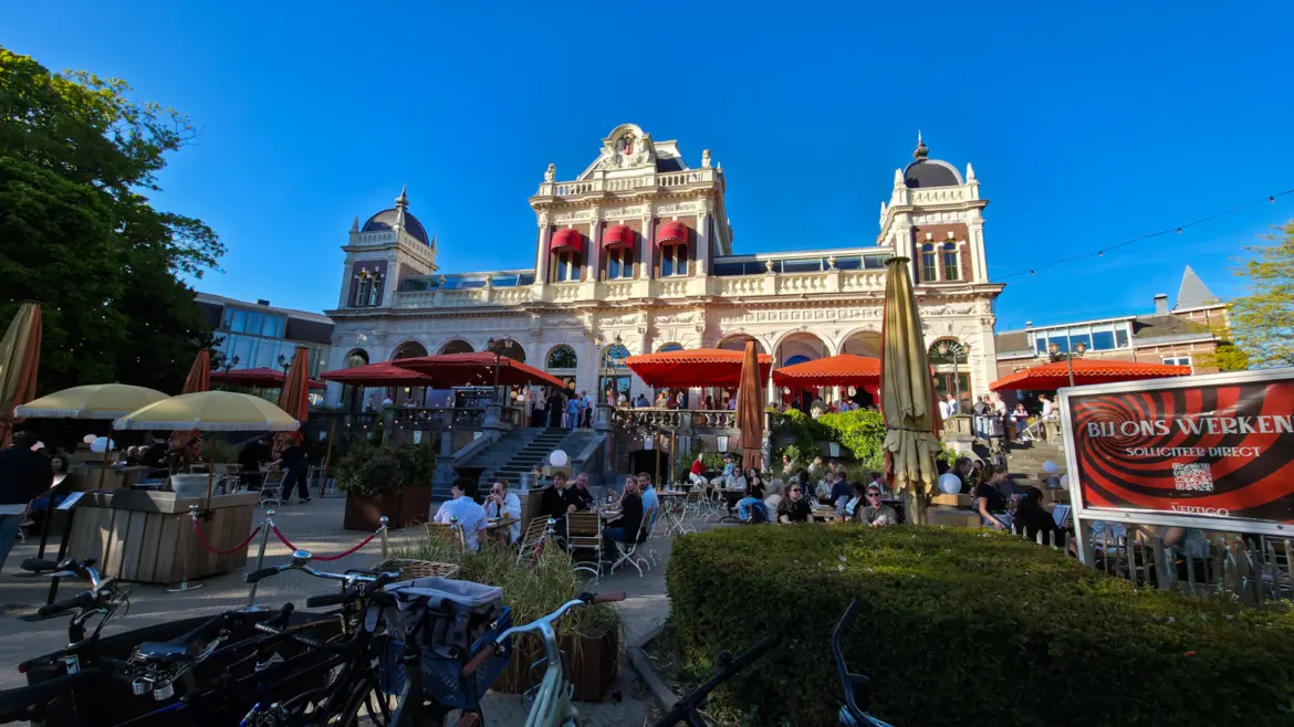 The Vondelpark Pavilion with Café Vertigo’s terrace of red parasols below it, Amsterdam, on a clear evening in April