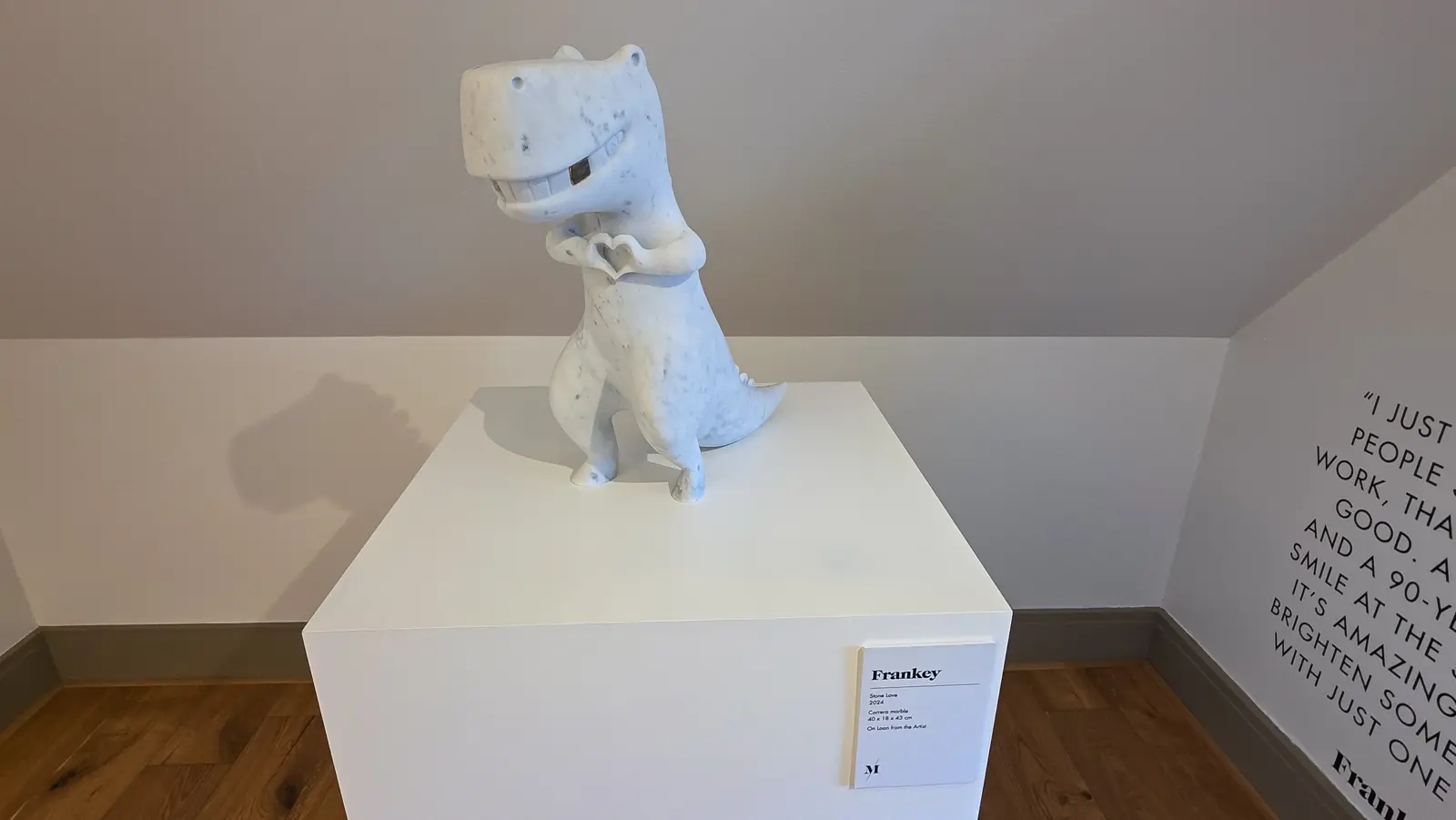 Stone Love by Frankey, a small white Carrara marble tyrannosaurus grinning and bringing its two short arms together to make a heart, Moco Museum, Amsterdam