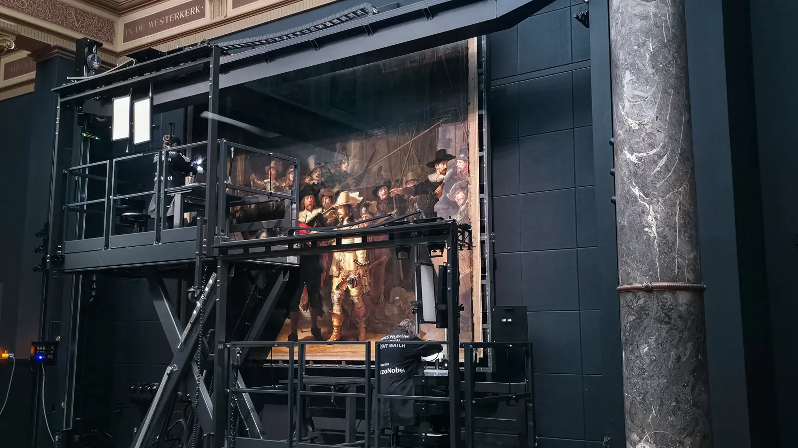 The Night Watch Gallery, Rijksmuseum, Amsterdam, with the restoration rig beside a marble column and gilded frieze lettering above