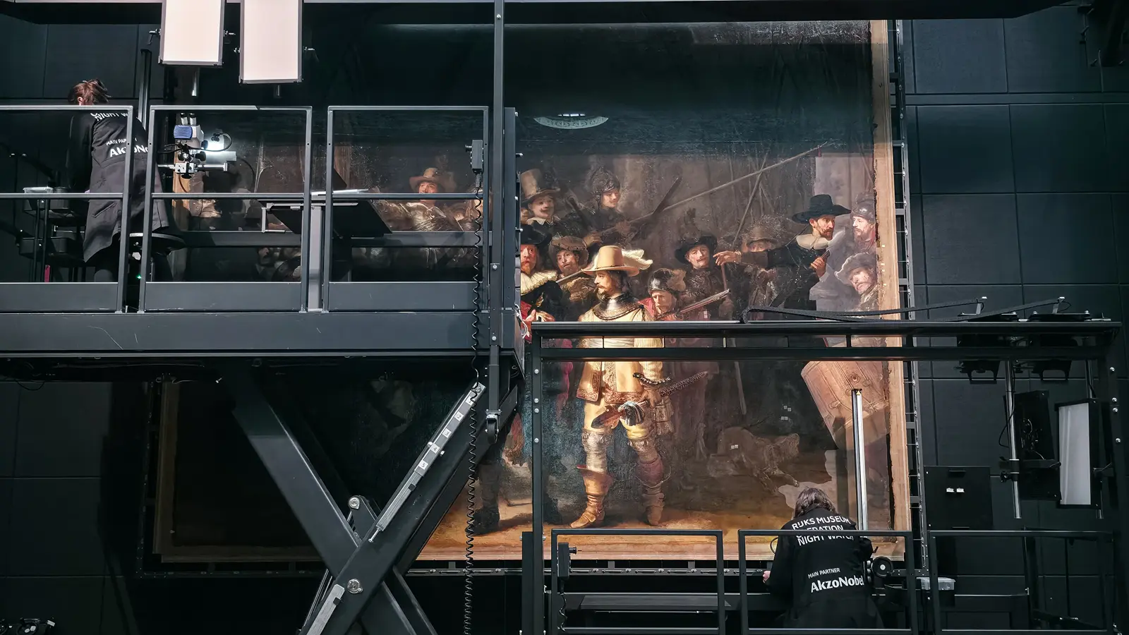 The Night Watch during varnish removal at the Rijksmuseum, Amsterdam, with conservators working at the lower right and upper left of the canvas