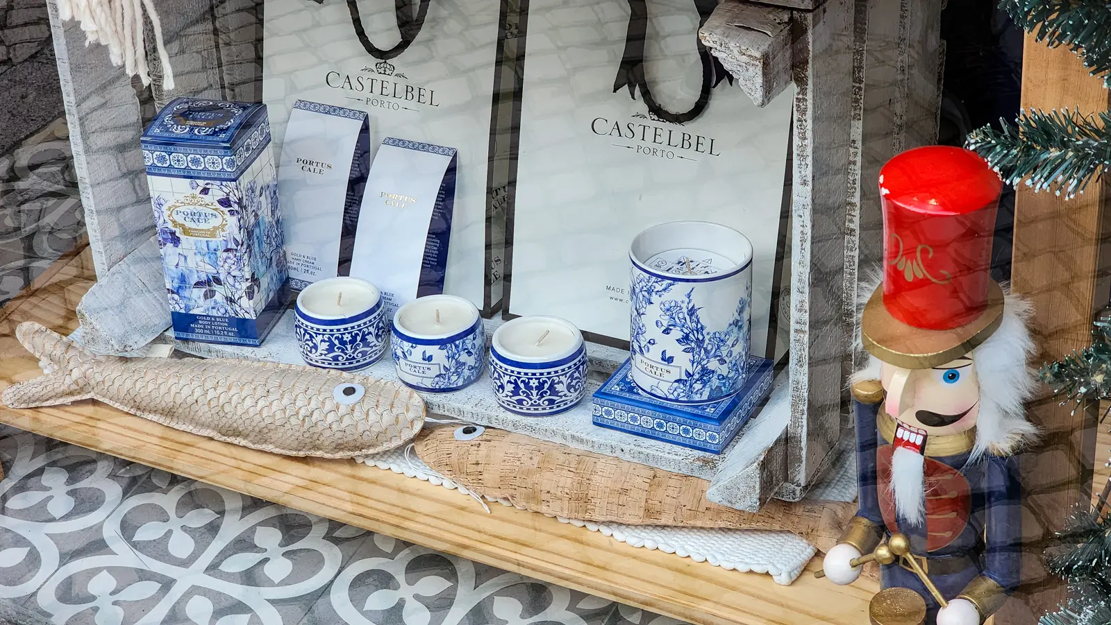 Shop window in Príncipe Real, Lisbon, with blue and white patterned soap and candle packaging on a wooden crate