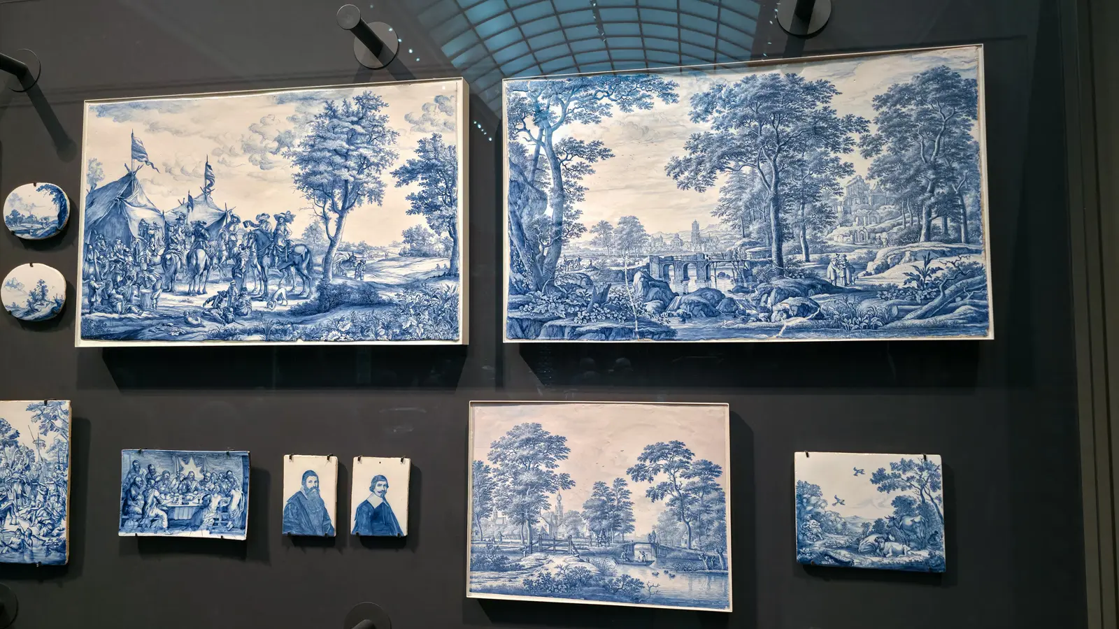 Wall of blue and white Delft earthenware plaques painted with landscapes, portraits and a Last Supper, Rijksmuseum