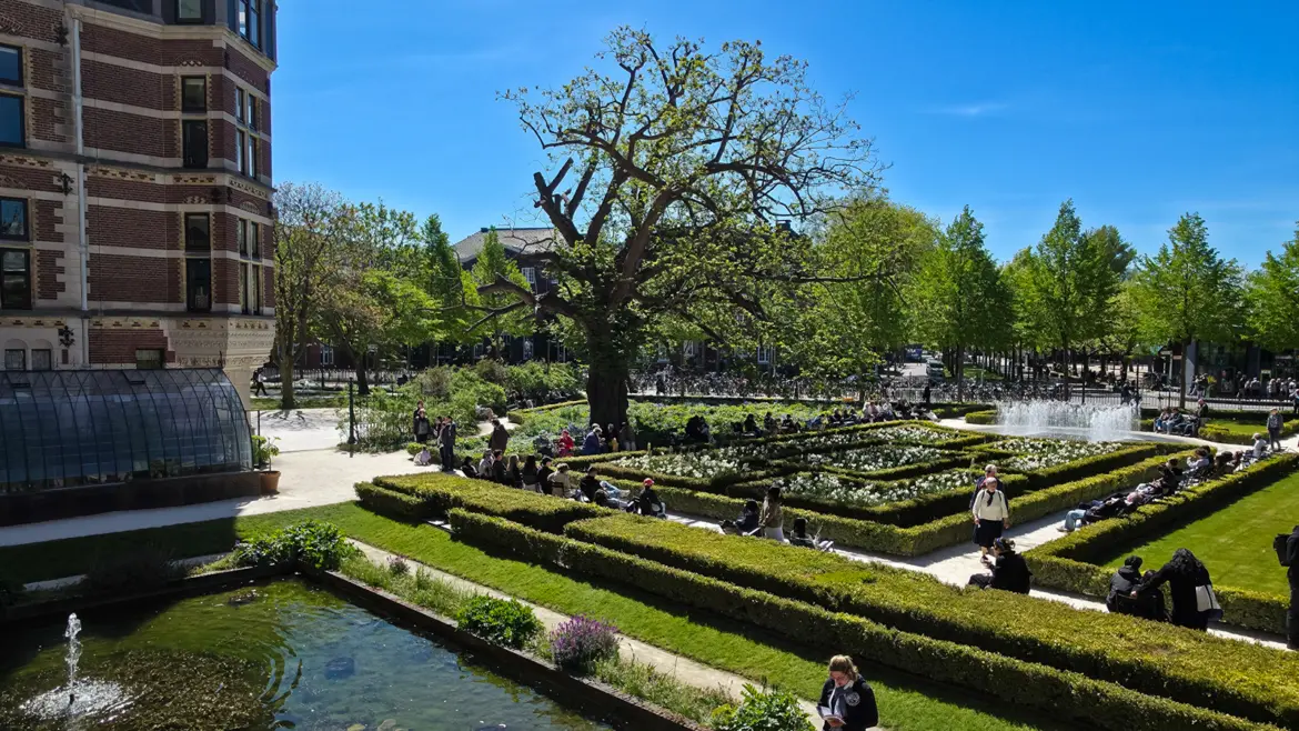Rijksmuseum gardens in spring, with clipped hedges, a sunken pond, a glasshouse and a fountain of jets, Amsterdam
