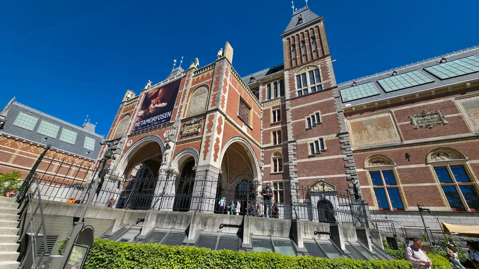 South front of the Rijksmuseum with its arched passage entrance, tower and tiled wall panels, seen from the garden steps