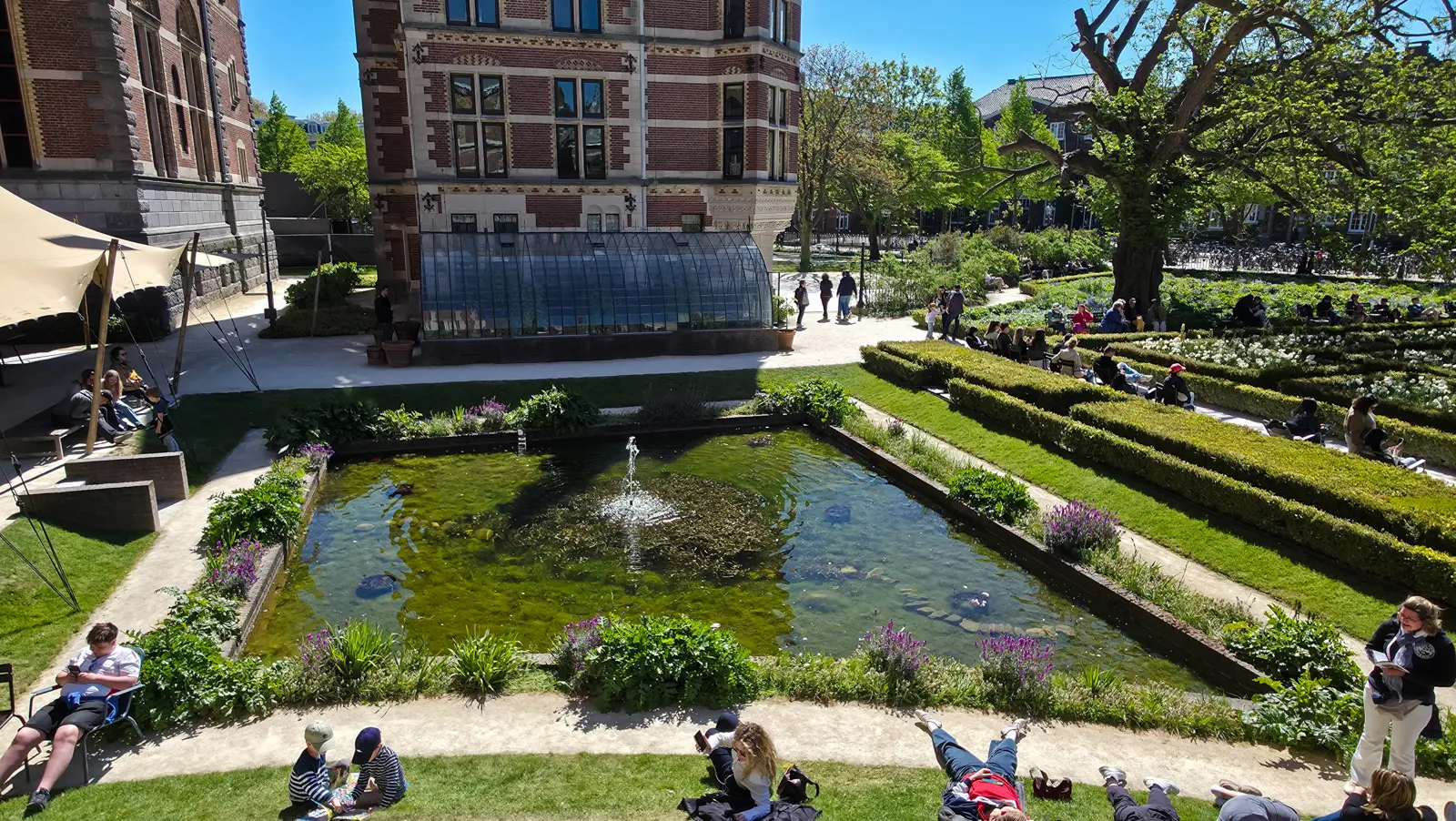 Sunken rectangular pond with a central jet and a long glasshouse behind it, Rijksmuseum gardens, Amsterdam