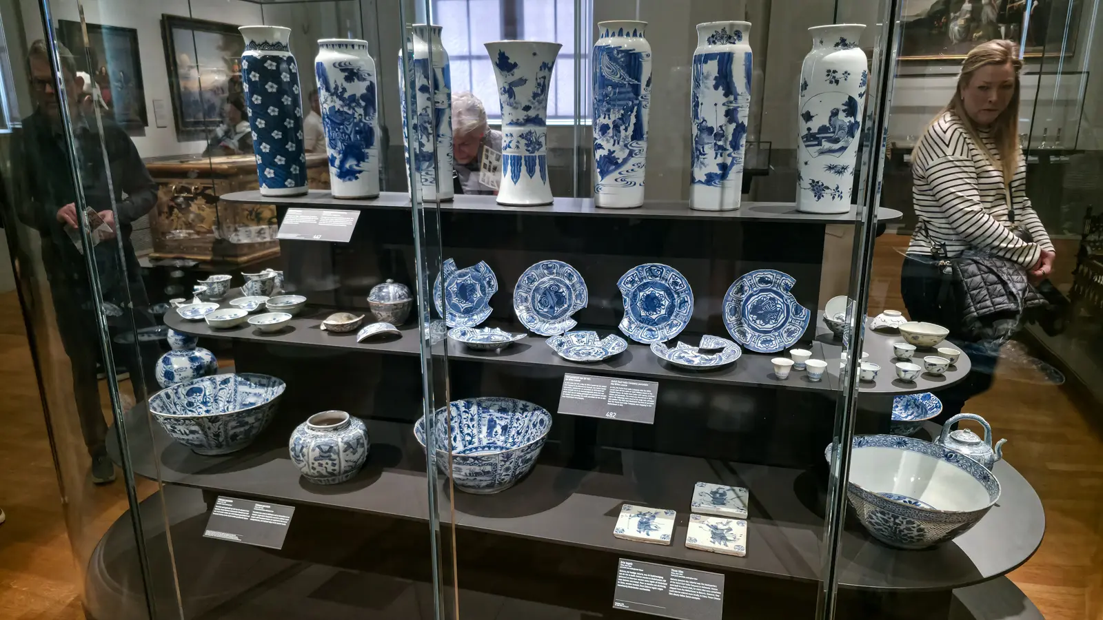 Wide museum case of Dutch East India Company porcelain with vases, bowls, plates and tiles, Rijksmuseum, Amsterdam