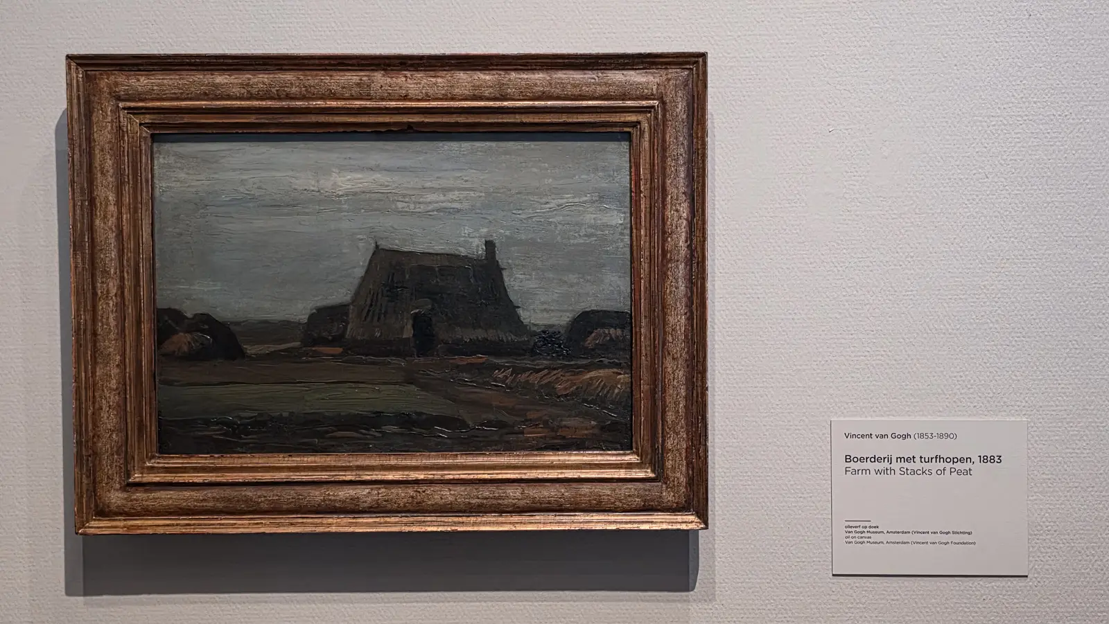 Farm with Stacks of Peat, 1883, a turf-roofed farmhouse and stacks of cut peat in brown, grey and dirty green, painted in Drenthe, Van Gogh Museum