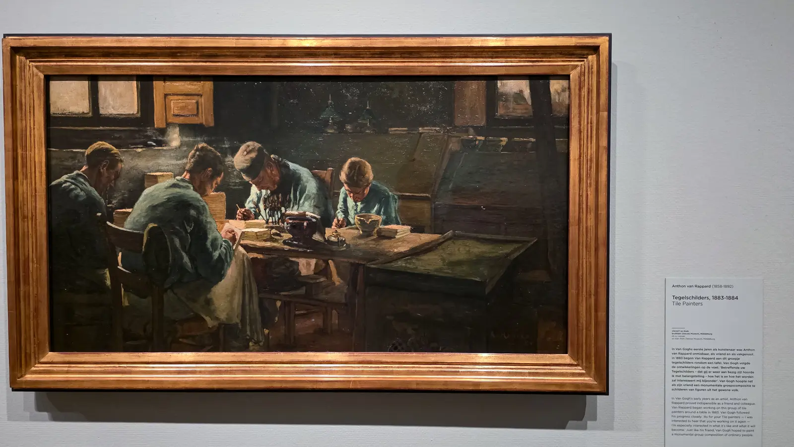 Tile Painters by Anthon van Rappard, 1883 to 1884, workers bent over a table painting tiles in a dim interior, on loan from the Zeeuws Museum, Van Gogh Museum