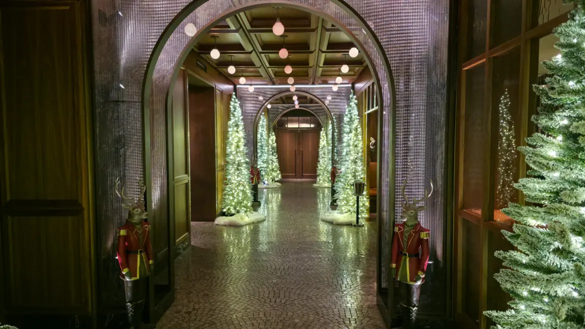 Arched corridor lined with lit Christmas trees and reindeer figures in red coats, Fairmont Royal York, Toronto, at Christmas