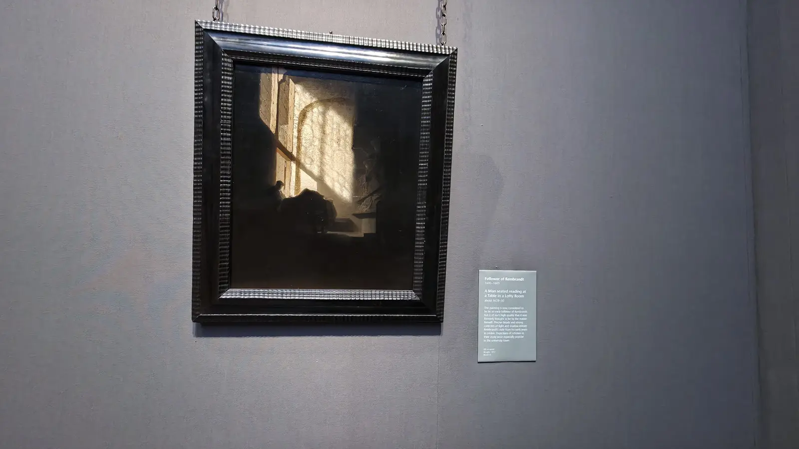 A Man seated reading at a Table in a Lofty Room, by a follower of Rembrandt, about 1628-30, National Gallery, London