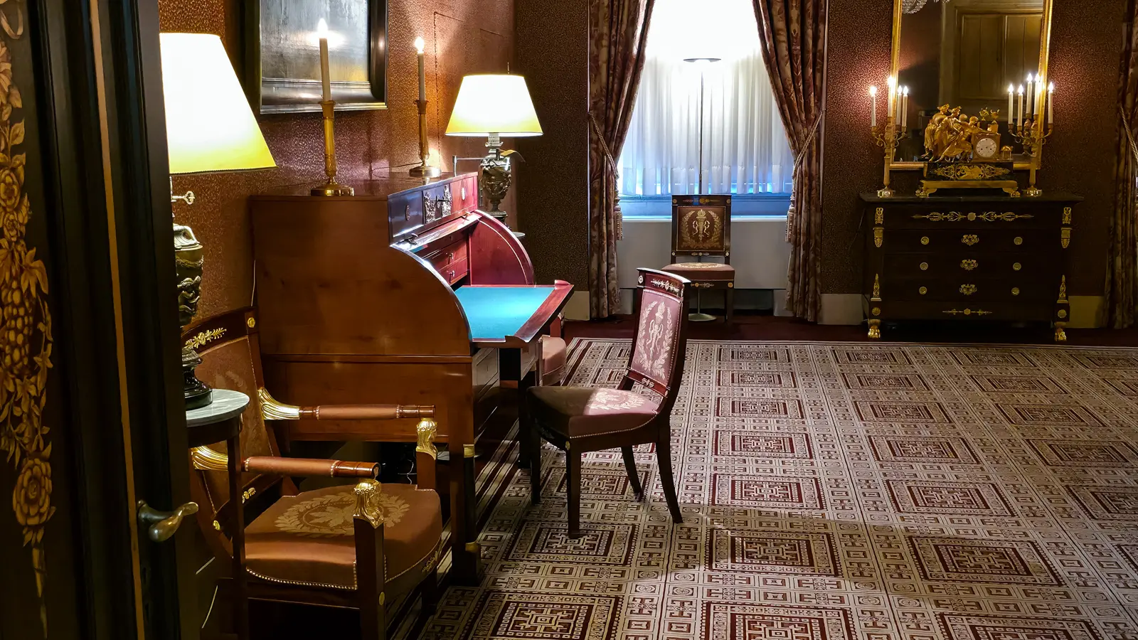 A roll-top writing desk with a green leather writing surface, candlesticks and Empire chairs in the Royal Palace Amsterdam