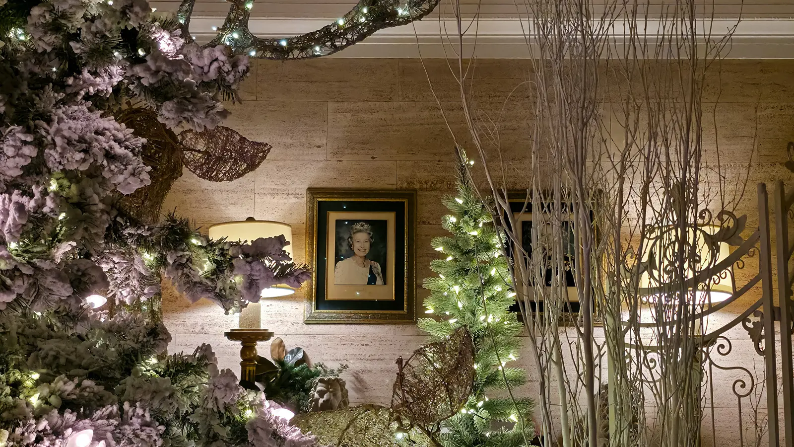 A framed portrait of Queen Elizabeth II on a stone wall, among frosted Christmas trees and lamps, Fairmont Royal York