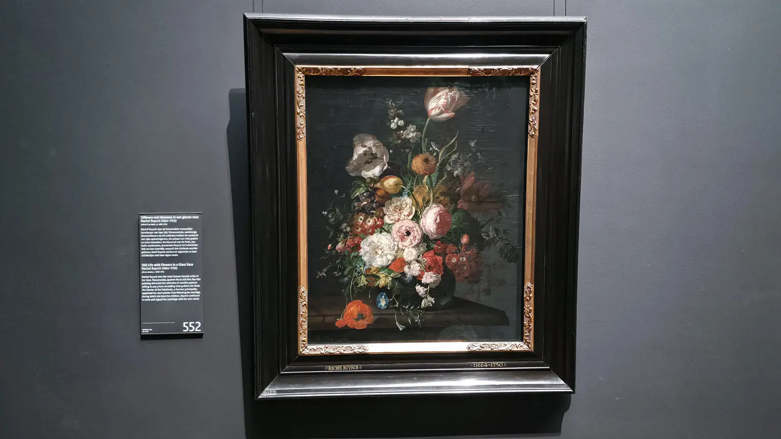 Rachel Ruysch's flowers in a glass vase, a striped tulip at the top, in a black and gilt frame at the Rijksmuseum