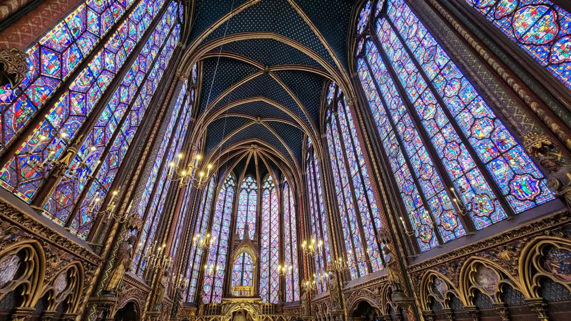 Upper chapel of Sainte-Chapelle, Paris, with stained-glass windows rising to a blue vault painted with gold stars