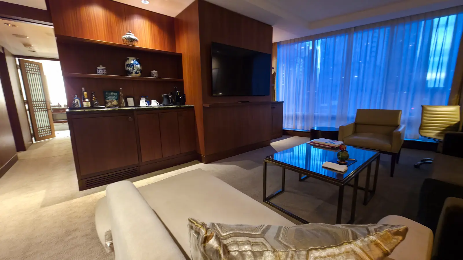 The Shangri-La Toronto suite living room seen from the chaise, with the television wall, bar cabinet, coffee table and windows