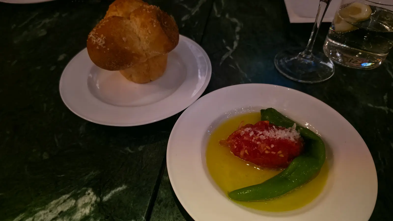 A salt-topped bread roll and a plate of grated tomato with a green pepper in olive oil at The Duchess, Amsterdam
