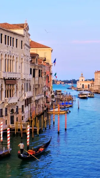 A panoramic look at the Grand Canal in Venice. Gondolas gliding, vaporettos passing and centuries of history reflected in ...